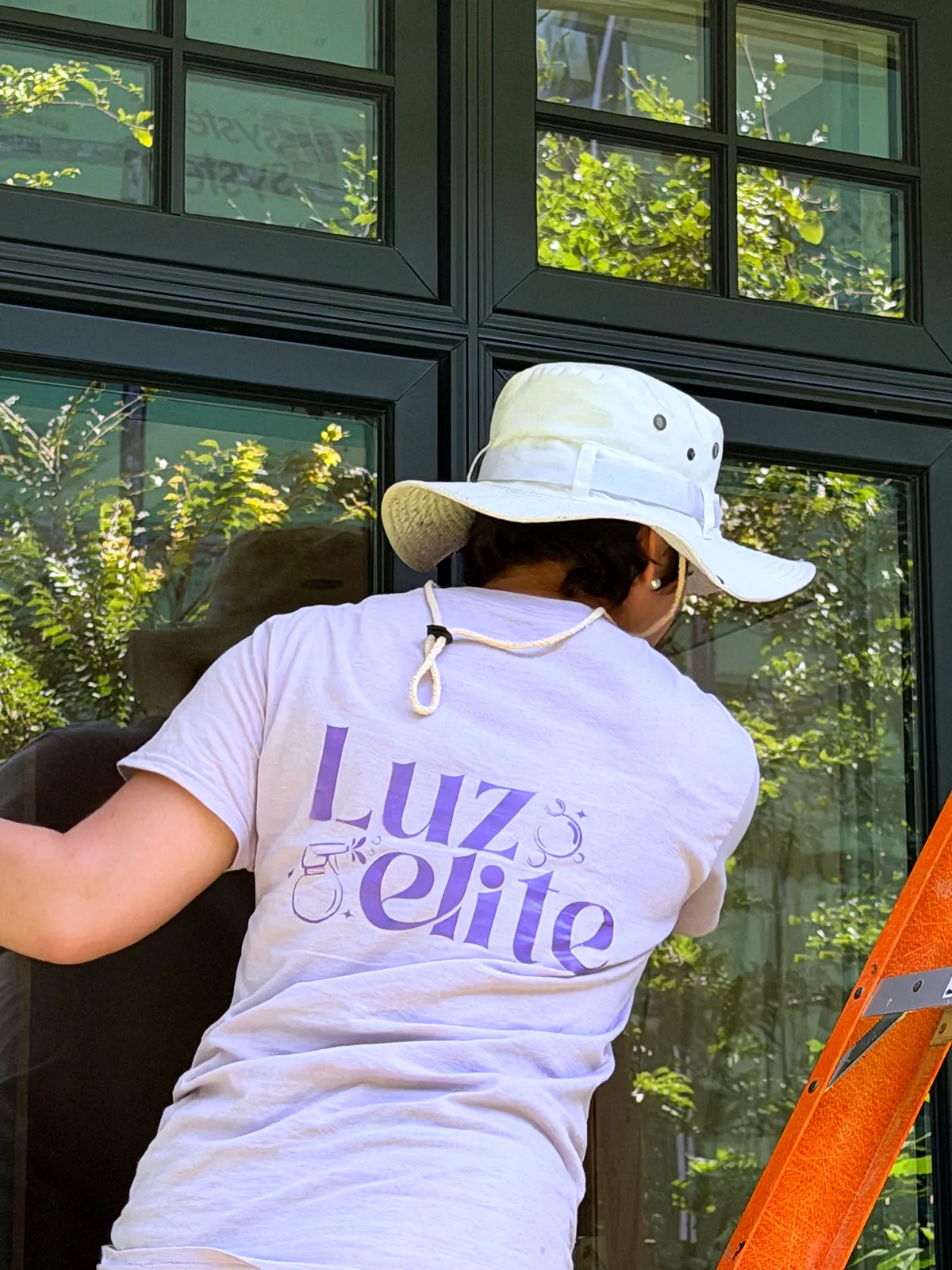 Luzelite team member cleaning windows
