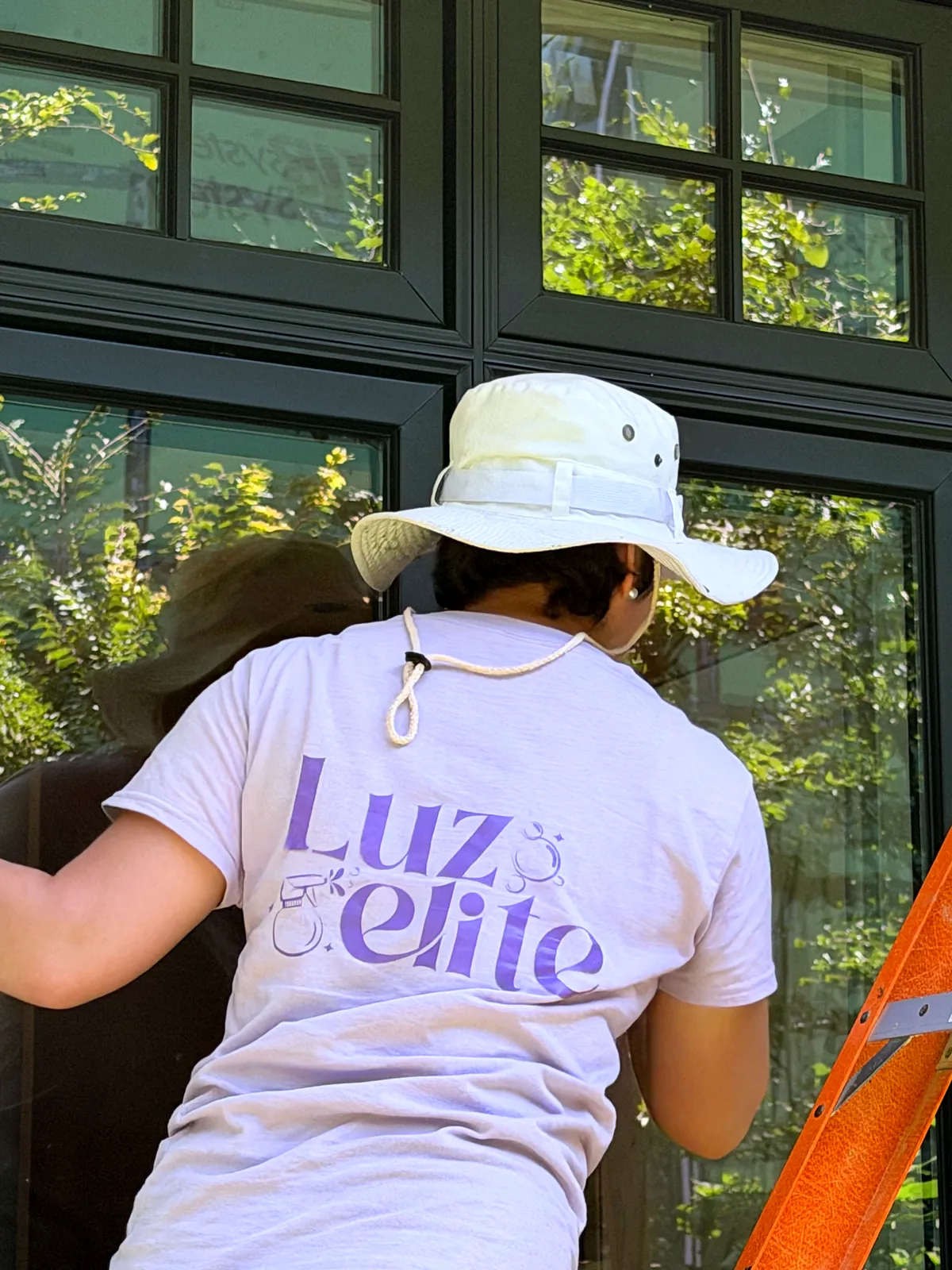 Luzelite team member cleaning windows